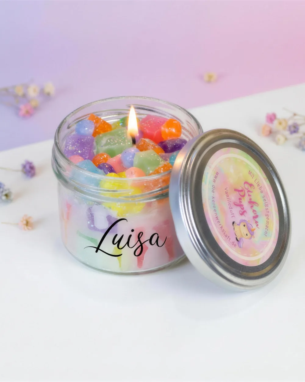 Dieselbe Duftkerze als Studio-Produktfoto vor pastelligem Hintergrund mit Trockenblumen (nachher)